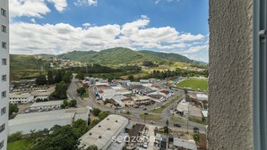A view of a town with buildings, roads, and mountains in the background. - Apt in Condo w/ Pool and Gym Rgk1202 (Poços de Caldas)