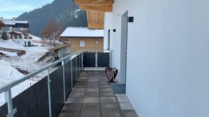 A balcony with a view of a snowy landscape and a mountain in the background. - Haus Schernthaner (Saalbach)
