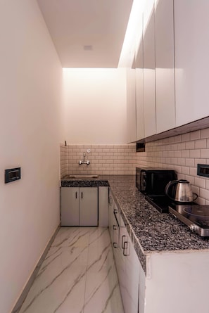 Deluxe Suite | Private kitchen | Fridge, microwave, oven, cookware/dishes/utensils