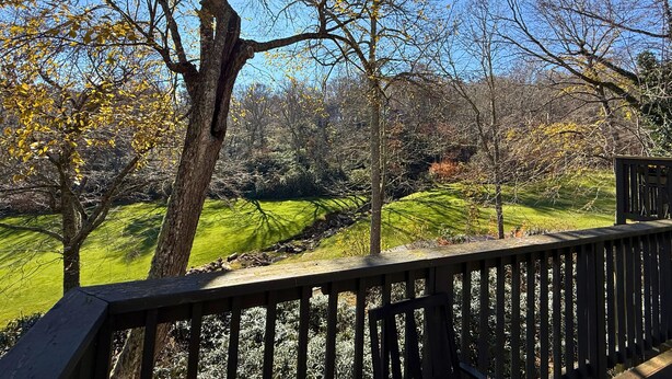 A wooden deck overlooking a green landscape with trees and a clear sky. - Spacious Sugar Mountain Condo with Golf Course Views & Prime Location (Sugar Mountain)