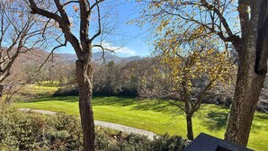 A view of a well-maintained lawn with trees and a clear sky. - Spacious Sugar Mountain Condo with Golf Course Views & Prime Location (Sugar Mountain)