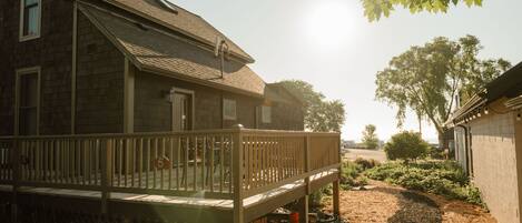 A house with a wooden deck, a garage, and a garden area.