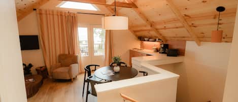 Een knus loft-appartement met een eethoek, een keuken en een trap.