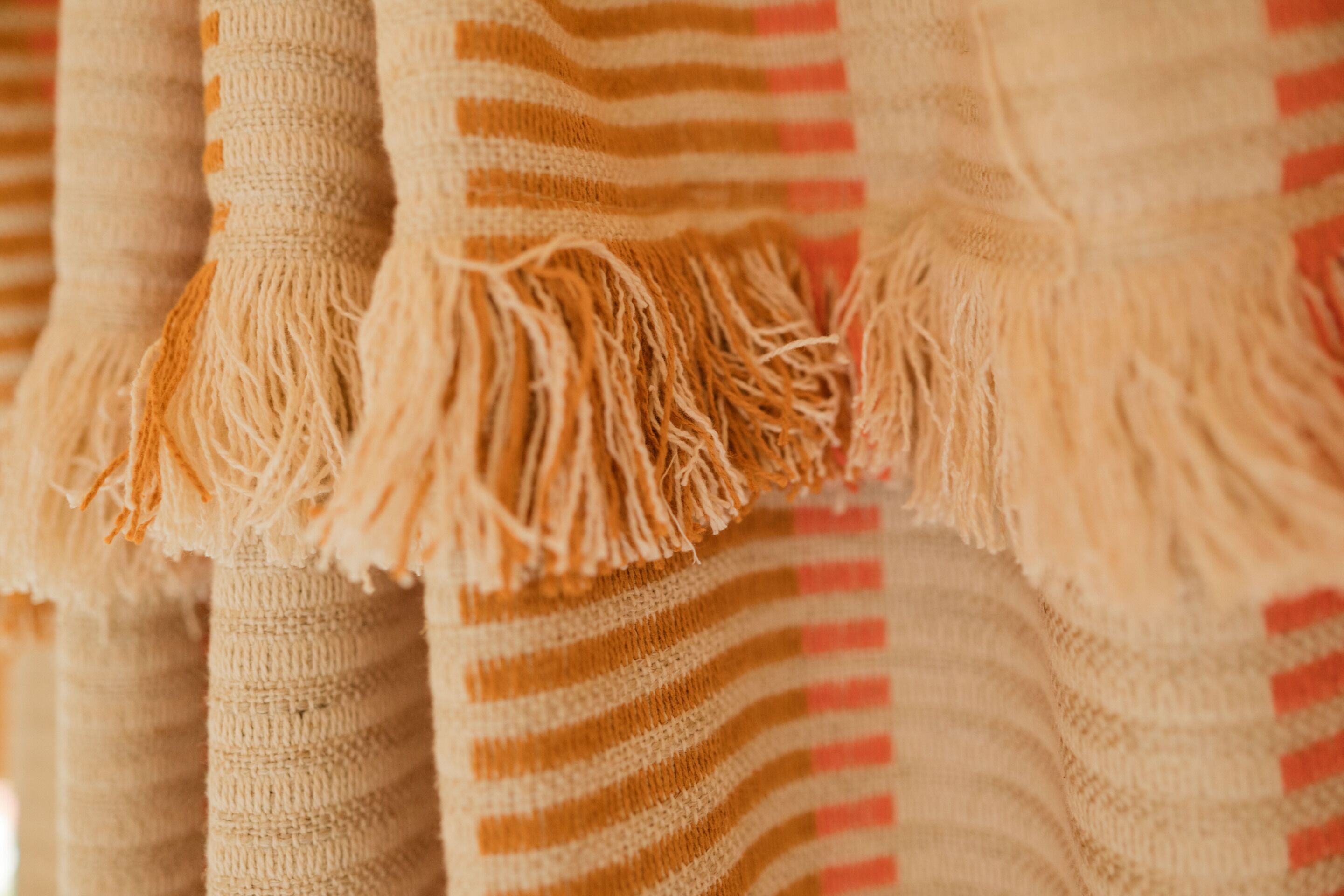 A close-up of a striped fabric with fringe details.