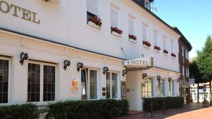 A white building with a sign reading "HOTEL" and multiple windows with shutters. - Posthotel Monegro  (Steinfurt)