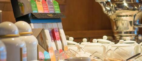 A buffet setup with various food items and a selection of beverages.