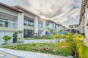 A modern building with multiple balconies and a landscaped garden area. - Condominium w/ Pool, 900 m fr/ the Beach, Imbassai Top Flats - Itfs (Mata de São João)