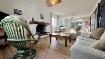 Un salon avec une cheminée, un canapé, un fauteuil à bascule et une table basse.