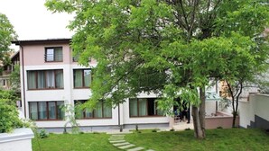 Un bâtiment moderne à deux étages, doté d’une pelouse bien entretenue et d’un chemin en pierre menant à l’entrée.