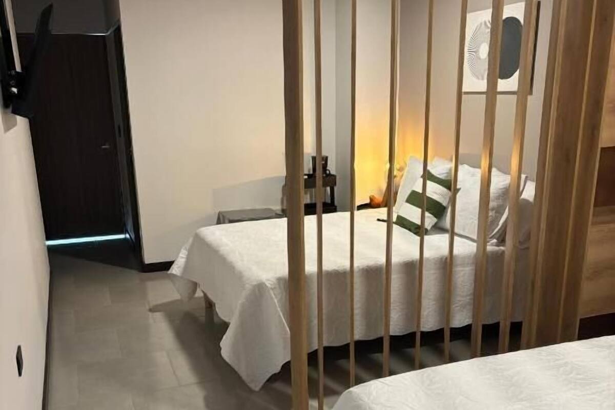 A hotel room with two beds, a desk, and a chair.