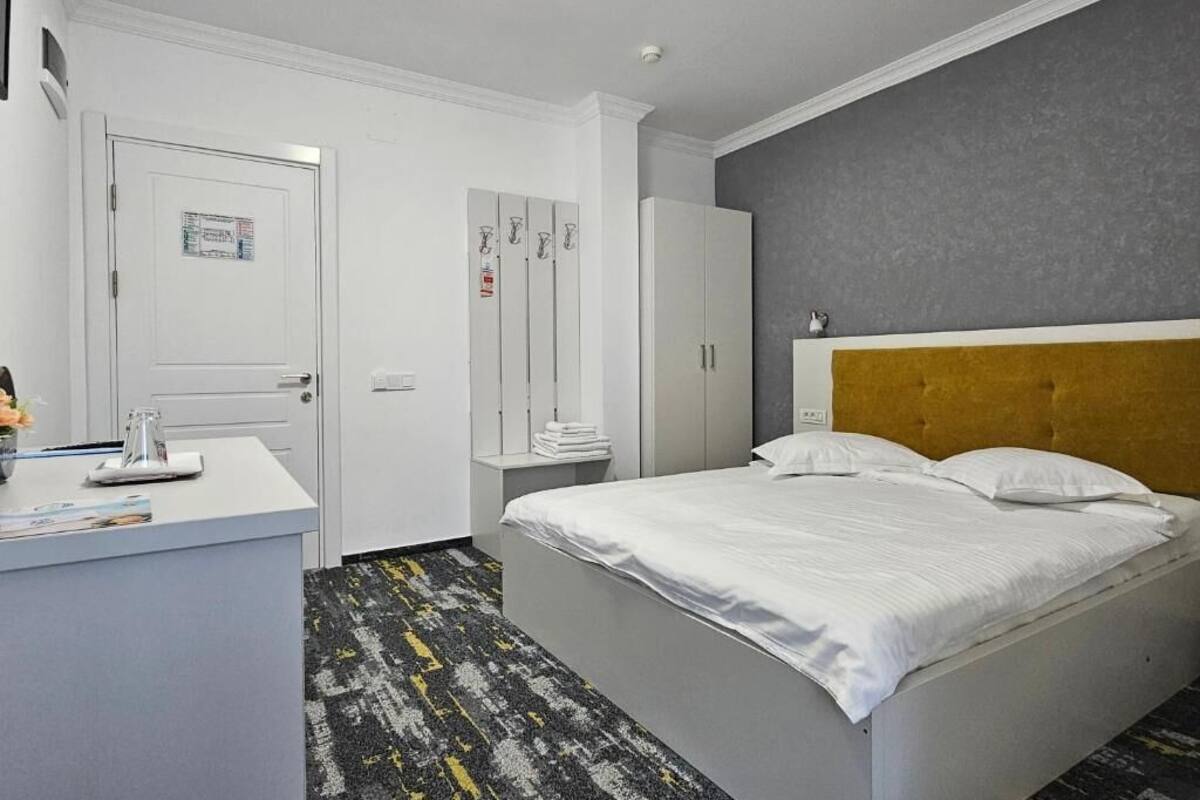 A hotel room with a bed, a desk, a wardrobe, and a bathroom.