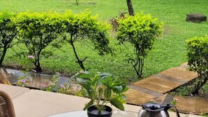 Una mesa de vidrio redonda con alimentos para el desayuno, una planta en maceta y un hervidor.