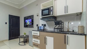 Una cocina compacta con microondas, tostadora y cafetera.