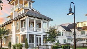 A multi-story house with a balcony on the second floor, a porch on the first floor, and a street lamp in the foreground. - Grace at Patience 12-Family Escape-Sleeps 10 (Inlet Beach)