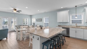 A spacious kitchen with a large island, white cabinetry, and a ceiling fan. - Walk to Beach 7BR Home w/ Private Pool & Beachside Charm (Surfside Beach)