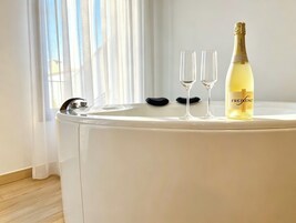 Un tocador blanco con una botella de champán y dos copas.
