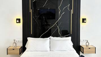 Un dormitorio moderno con una cama grande, dos mesitas de noche y una pared con diseño que imita el mármol negro.