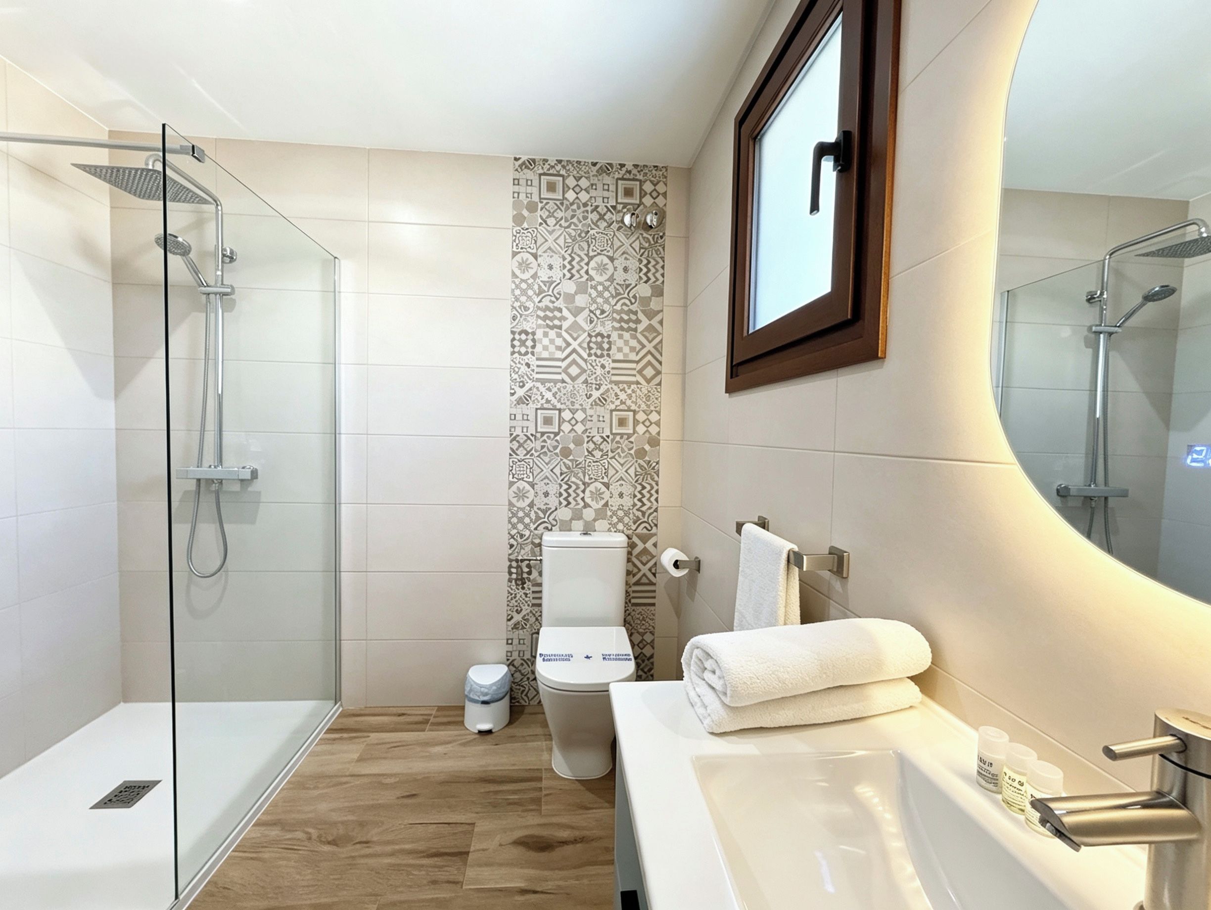Une salle de bain moderne avec une douche à parois de verre, des toilettes et un lavabo avec un miroir.