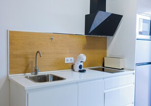 Departamento Deluxe, vista a la alberca | Cocina privada | Refrigerador con congelador, microondas y parrilla de estufa