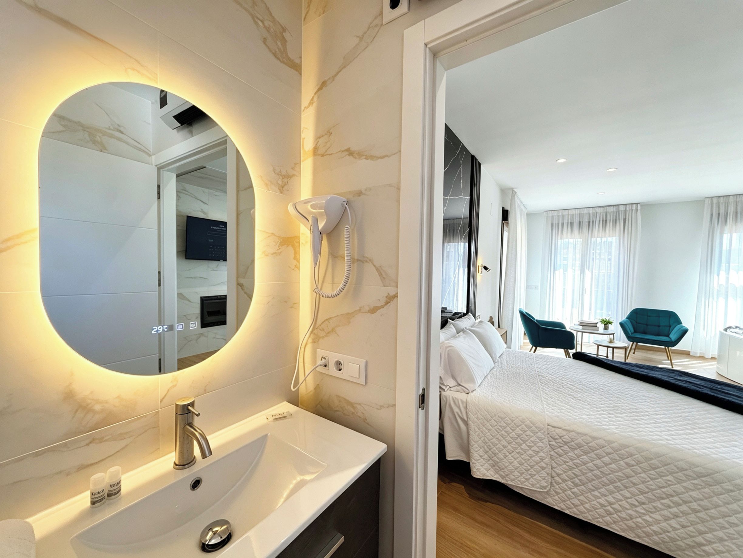 Un baño moderno con tocador de mármol, secador de pelo incorporado y termostato digital.