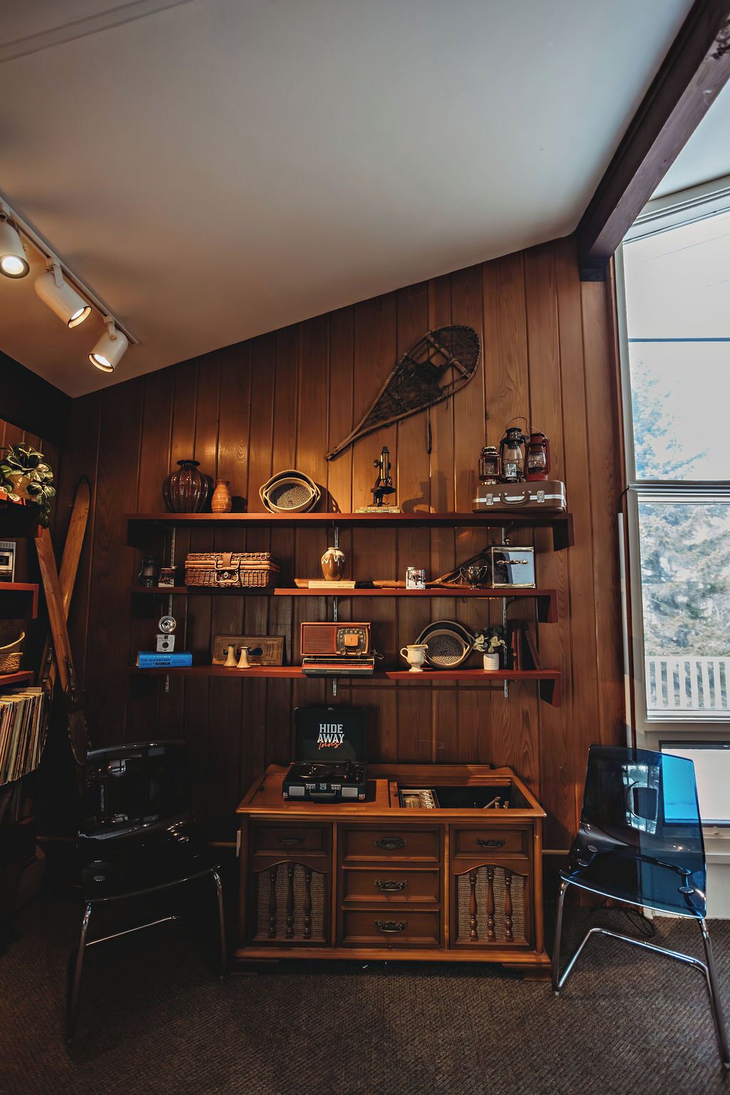 A cozy room with wooden paneling, a vintage radio, and a desk with a computer.