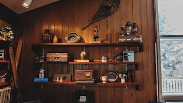 Een gezellige kamer met houten lambrisering, een vintage radio en een bureau met een computer.