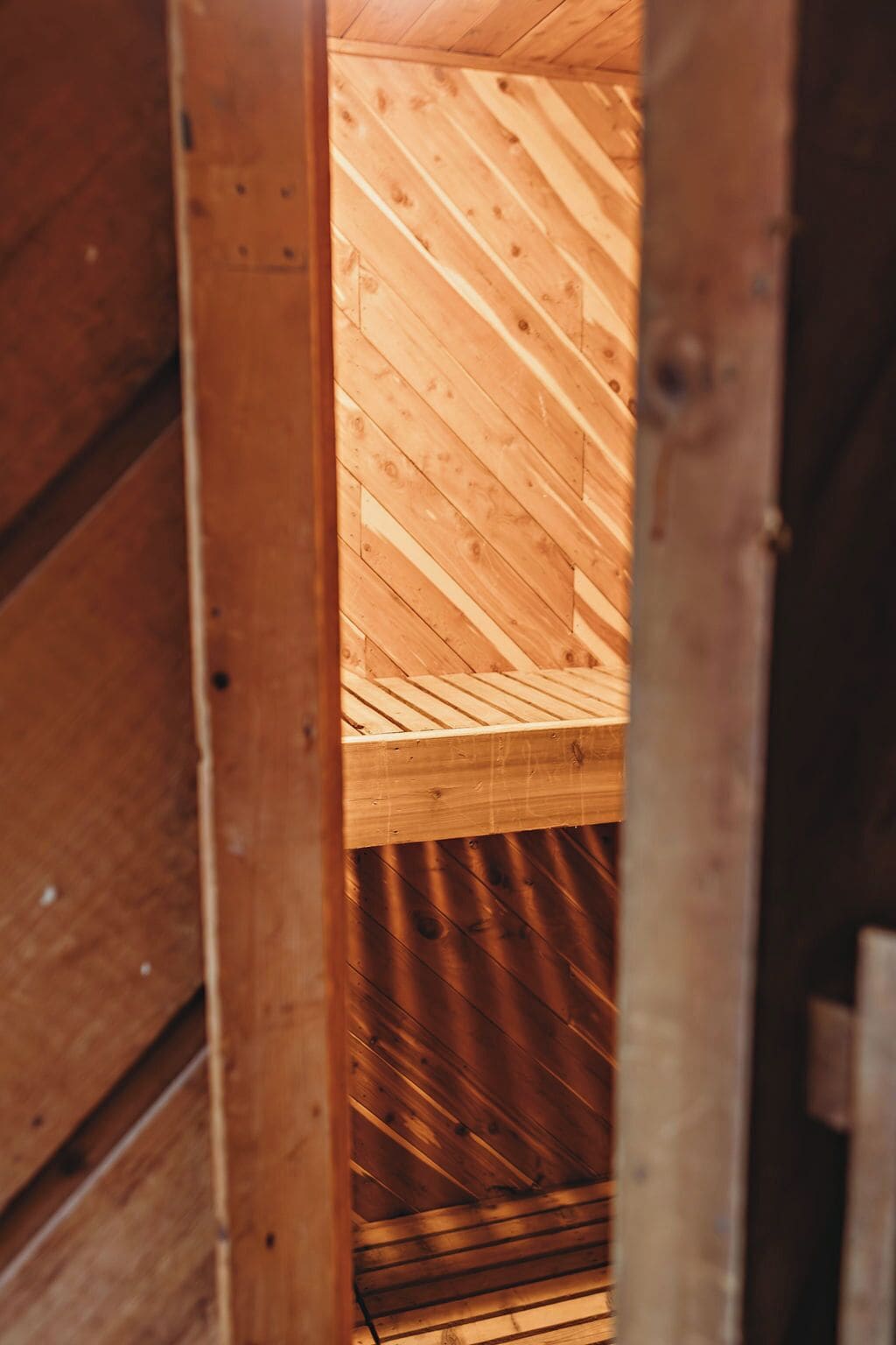 Interior de madera con techo inclinado y vigas a la vista.