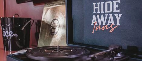 Une platine vinyle dotée d’un écran affichant le texte « HIDE AWAY Inns ».