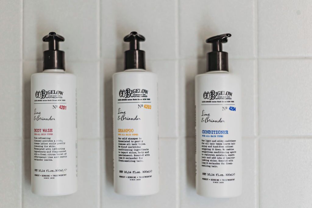 Three bottles of CoBigelow products: body wash, shampoo, and conditioner, each labeled with the product name and number.