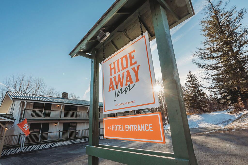 A hotel entrance sign with a 'Hide Away' sign above it, indicating the name of the hotel.