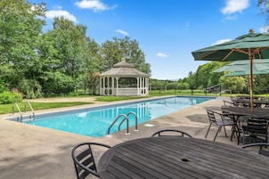 Una piscina al aire libre de temporada, sombrillas