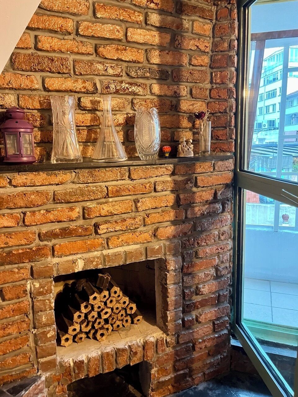 Una chimenea de ladrillo con jarrones decorativos y un farol.