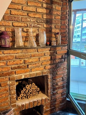A brick fireplace with decorative vases and a lantern. - Palmy Istiklal (İstanbul)