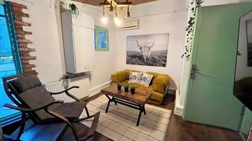 A cozy living room with a rocking chair, a yellow sofa, and a coffee table.
