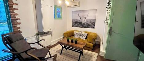 A cozy living room with a rocking chair, a yellow sofa, and a coffee table.