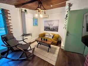A cozy living room with a rocking chair, a yellow sofa, and a coffee table. - Palmy Istiklal (İstanbul)