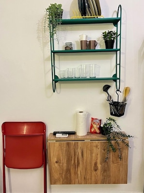 A wooden cabinet with a remote control, a roll of toilet paper, and a packet of snacks. - Palmy Istiklal (İstanbul)