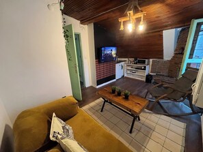 A cozy living room with a sofa, a coffee table, and a TV in the background. - Palmy Istiklal (İstanbul)