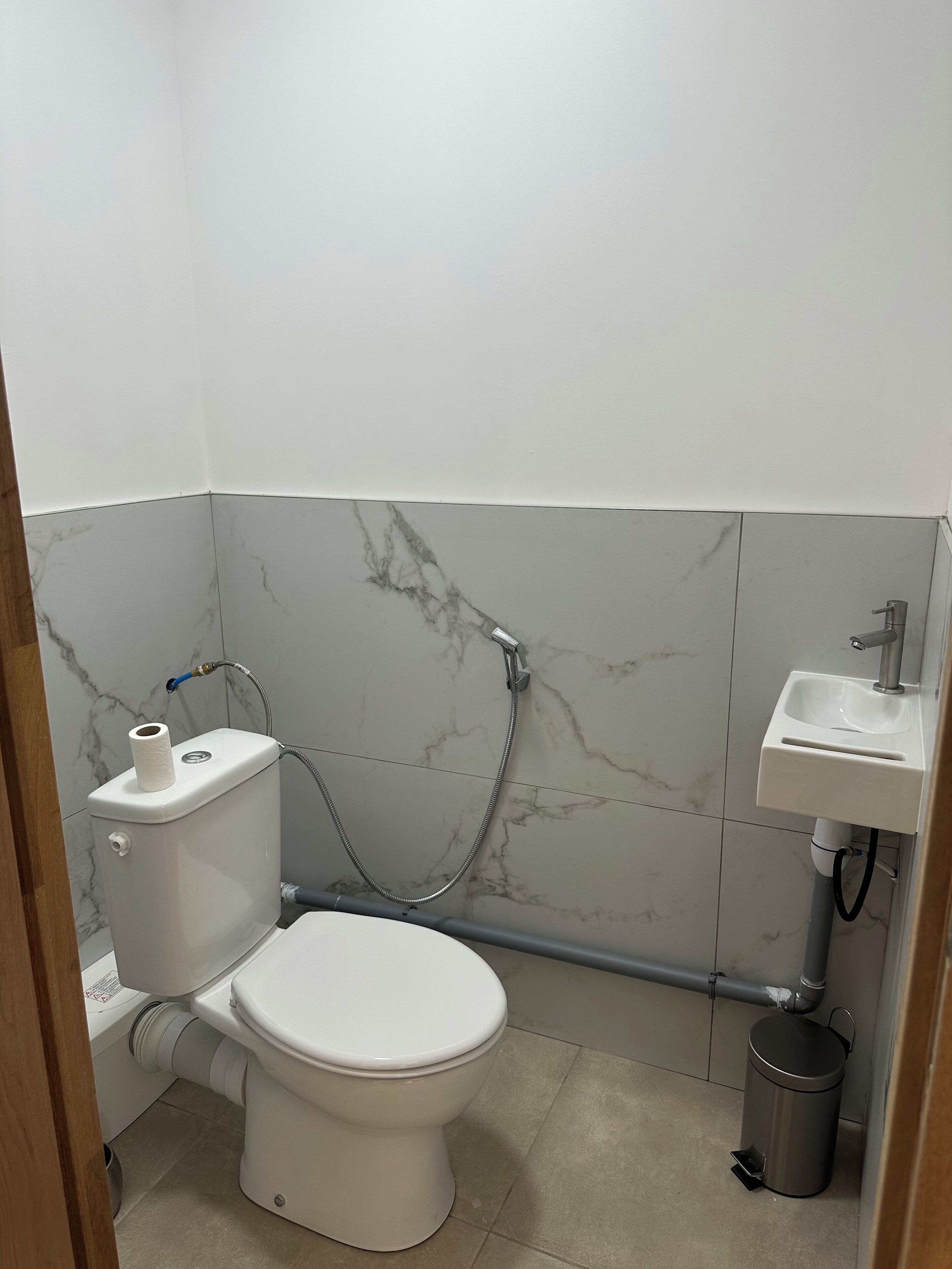 Un baño pequeño con inodoro, lavamanos y ducha.