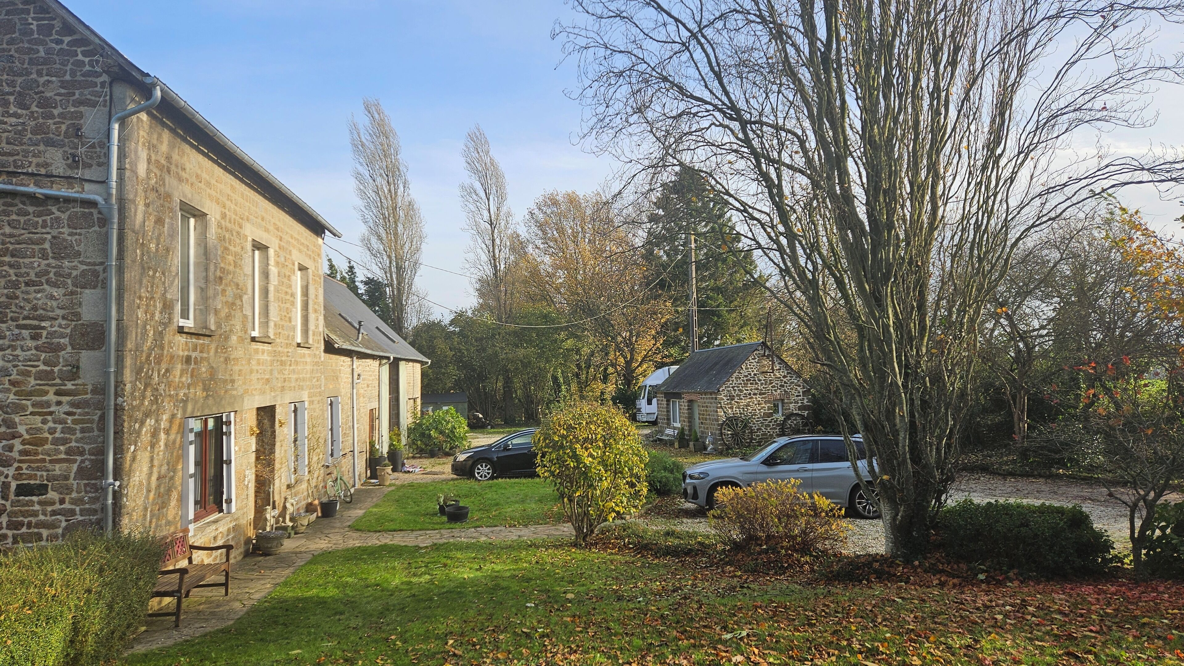 A stone building with a paved driveway and a small lawn area.