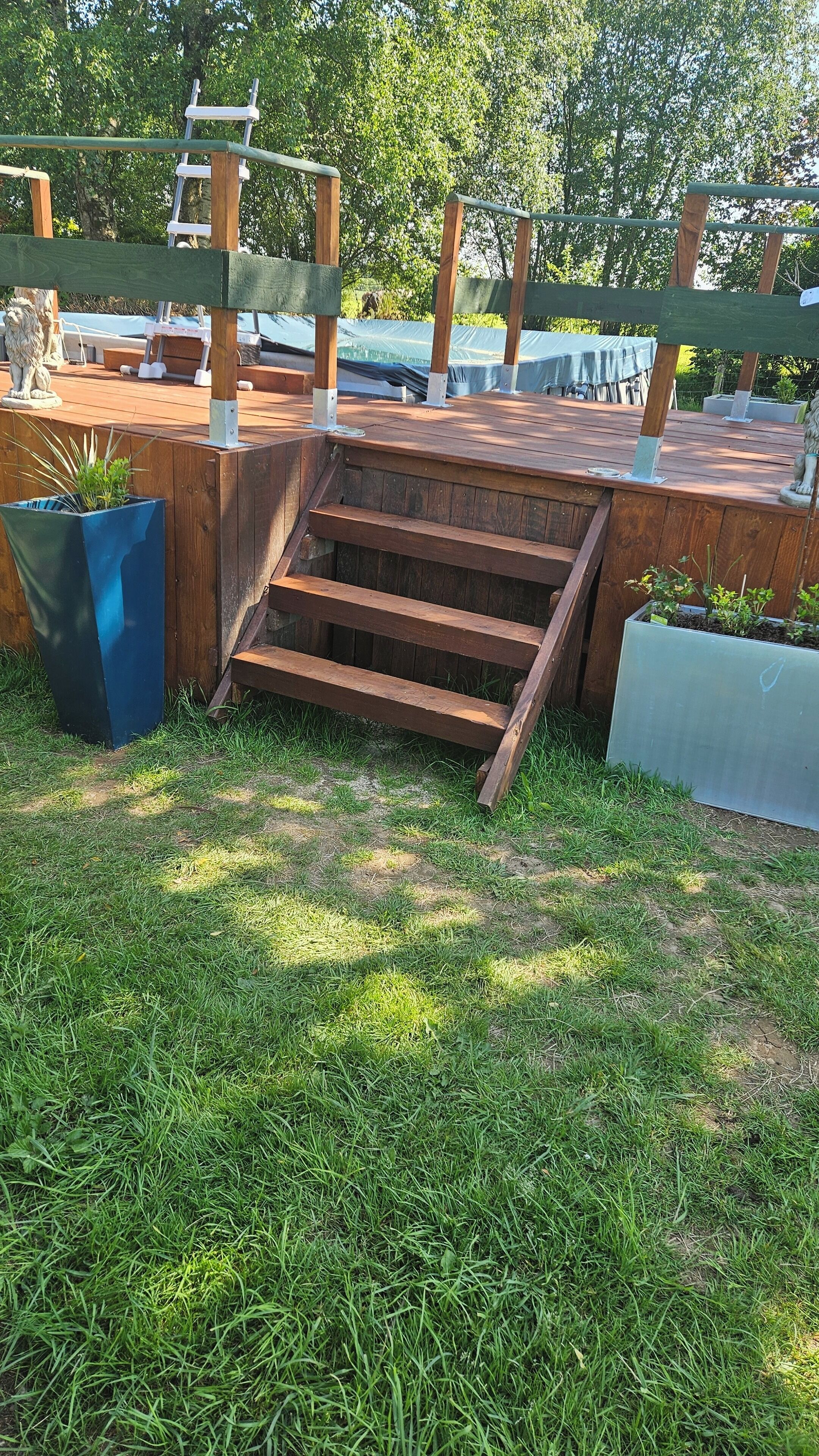 A wooden deck with a set of stairs leading up to a covered area.