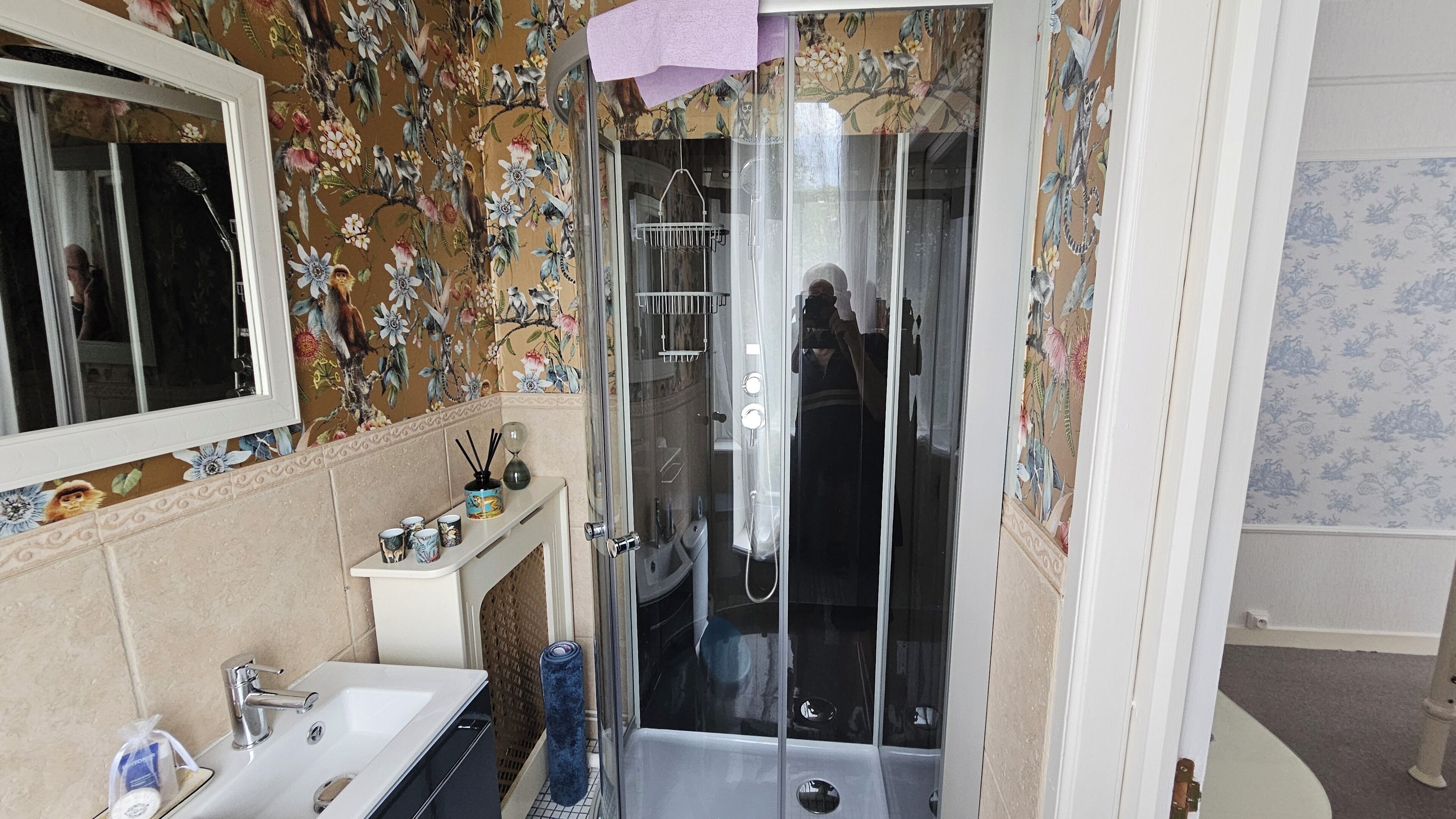 Un baño con ducha de vidrio, lavabo y espejo.