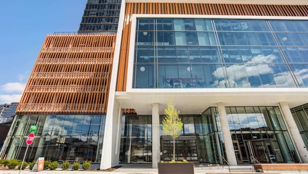 A modern building with large glass windows, a wooden facade, and a clear sky. - Kenect Nashville (Nashville)