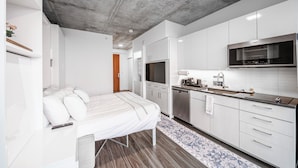 A modern kitchen with white cabinetry, a built-in microwave, and a stainless steel dishwasher. - Kenect Nashville (Nashville)