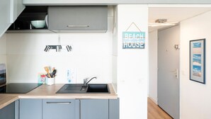 Une cuisine moderne équipée d’un évier, de placards et d’une enseigne indiquant « Beach House ».