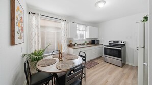 A compact kitchen with white cabinets, a microwave, and a stove. - Stay just minutes from Downtown in this cozy, well-designed 1-bedroom apartment. An ideal base for professionals, students, and travelers wanting fast access to Houston’s best dining and attractions. (Houston)