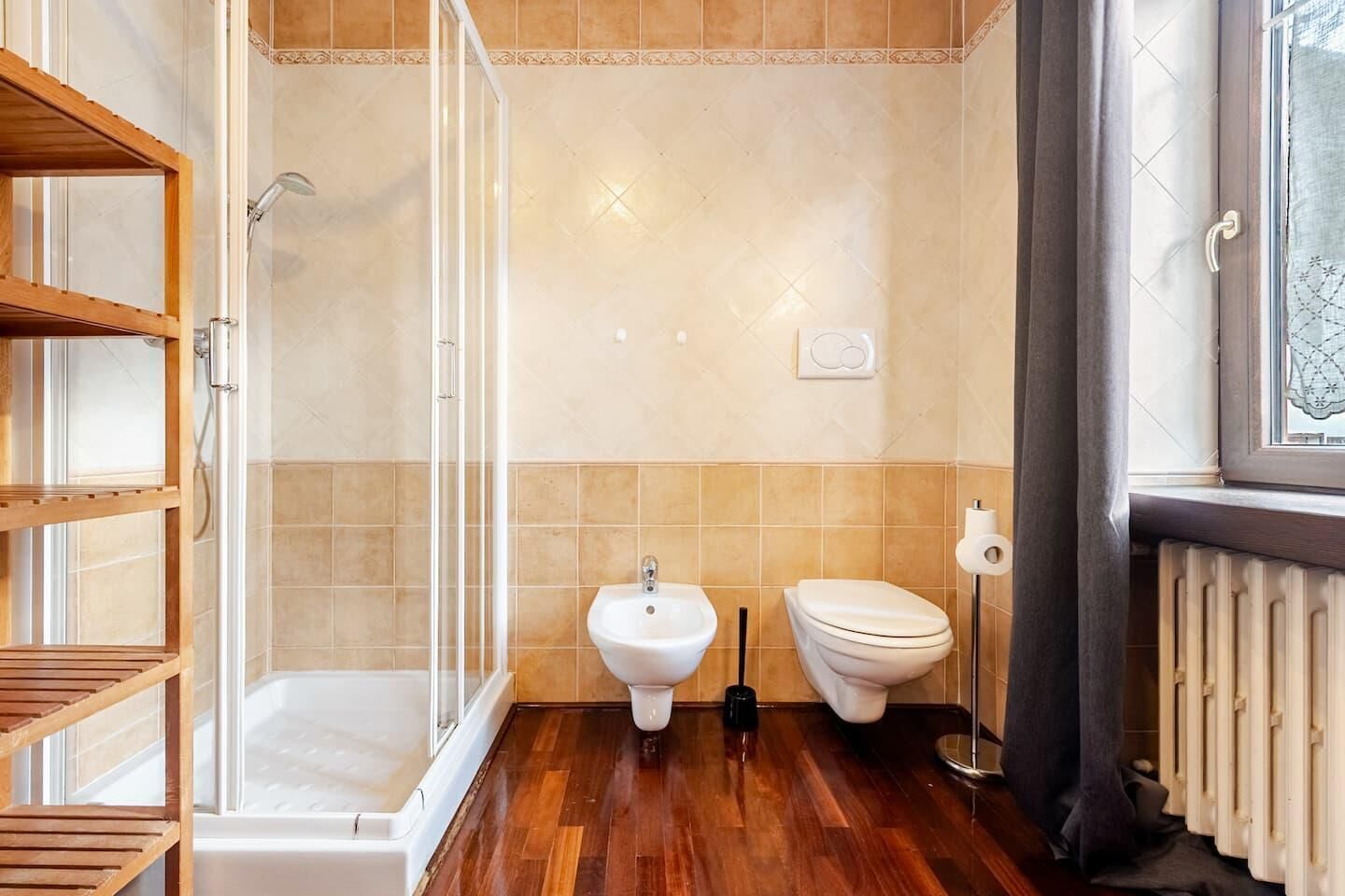 Ein Badezimmer mit Dusche, Bidet, Toilette und Handtuchheizkörper.