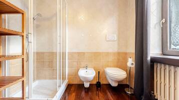 Ein Badezimmer mit Dusche, Bidet, Toilette und Handtuchheizkörper.