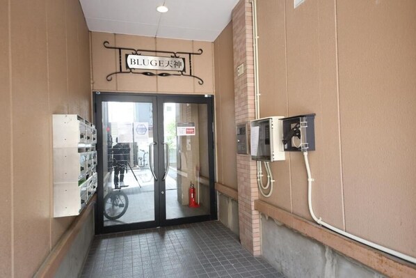 A hotel entrance with a sign reading 'BLUE Heaven,' a fire extinguisher, and a utility box on the wall. - goom Hotel Nakasu Bluge (Fukuoka)