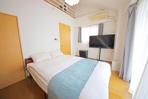 A bedroom with a bed, a television, an air conditioning unit, and a door. - goom Hotel Nakasu Bluge (Fukuoka)